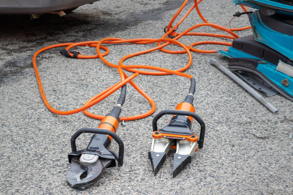 Two hydraulic rescue tools, shears and a spreader, on the ground